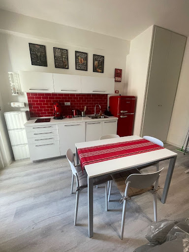 Cucina rossa Campari con dettagli Girmi vintage e piastrelle diamantate