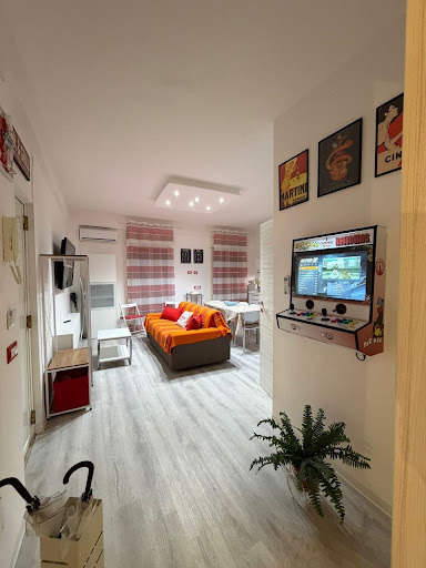 Zona giorno luminosa con bartop arcade e arredi vintage a Casa Campari